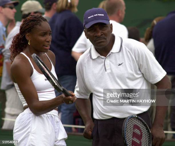 Player Venus Williams and her father and coach Richard Williams discuss a point 01 July 2000 during a training session with Venus' sister Serena...