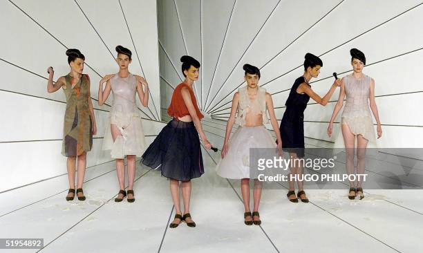 Two models chip away at two models presenting creations by designer Hussein Chalayan for the Spring/Summer 2001 collection, at London Fashion Week 27...