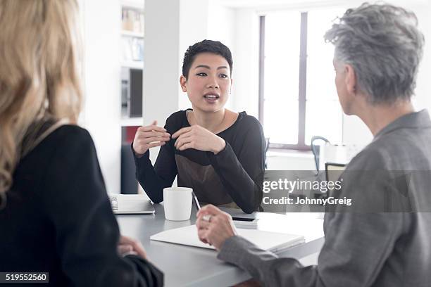 young woman talking and gesturing in business meeting - androgynous stock pictures, royalty-free photos & images