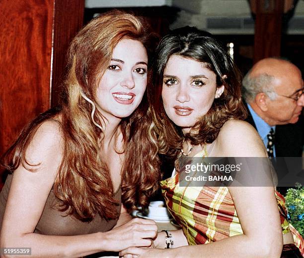 Lebanese actress Madeleine Tabr poses for a picture with Egyptian actress Ghada Adel during a dinner at a restaurant in Cairo late 22 December 2000....