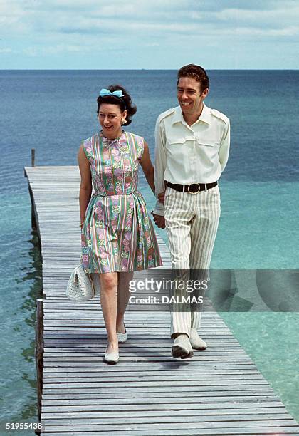 Princess Margaret, the younger sister of Britain's Queen Elizabeth II, walks 14 March 1967 with her husband Earl of Snowdon on a pontoon in the...