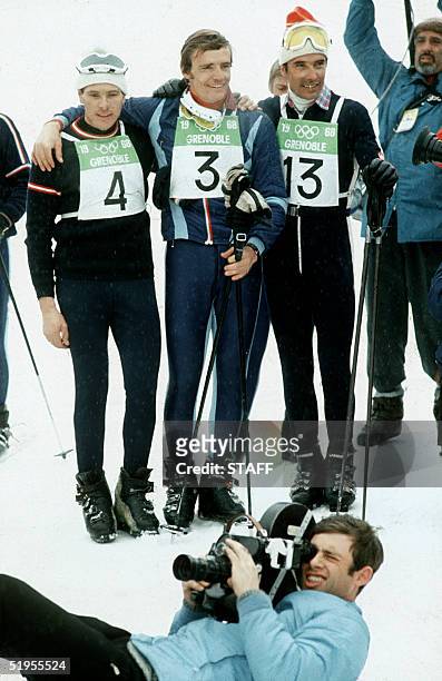 French skier Jean-Claude Killy, flanked by Austrian Heinrich Messner and Swiss Willy Favre, smiles for photographers 12 February 1968 in Chamrousse,...