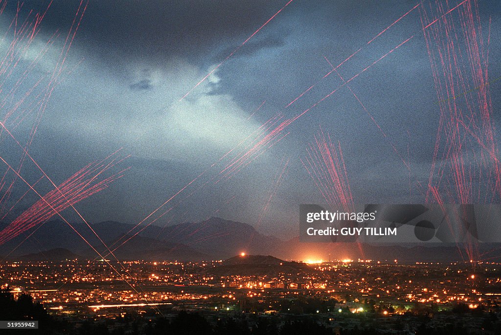 The evening sky is lit with tracer bullets and fla