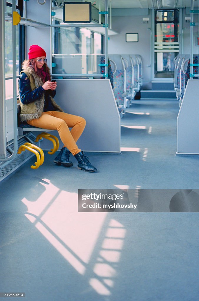 Donna utilizzando smartphone in treno