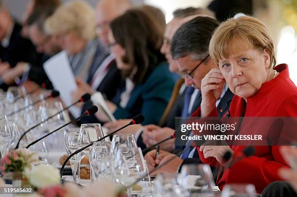 German Chancellor Angela Merkel adjust her earphone as she attends a lunch during the 18th Franco-German cabinet meeting in Metz, eastern France, on...