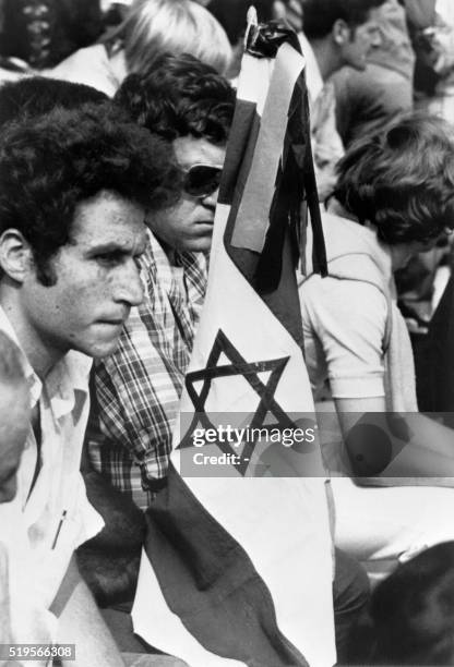 Members of the Israeli team holding an Israeli flag mourn during a memorial ceremony held on September 6, 1972 on the field of the Munich Olympic...