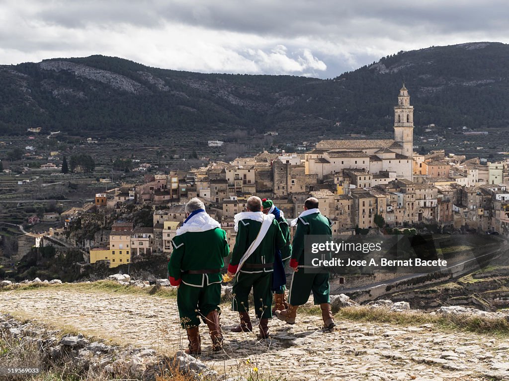 Men walking with gowns in the mountains