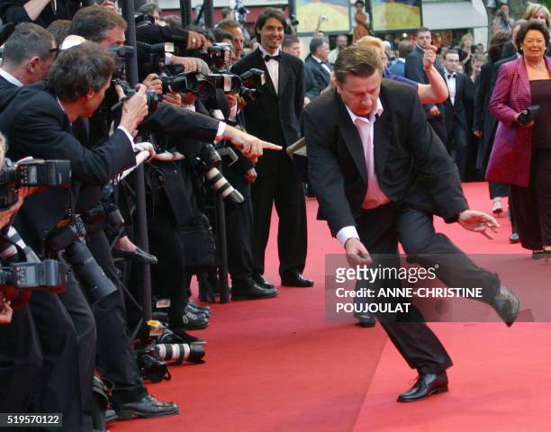 Finnish director Aki Kaurismaki dances on the red carpet as he arrives at the Palais des festivals to attend the screening of his film "L'Homme sans...