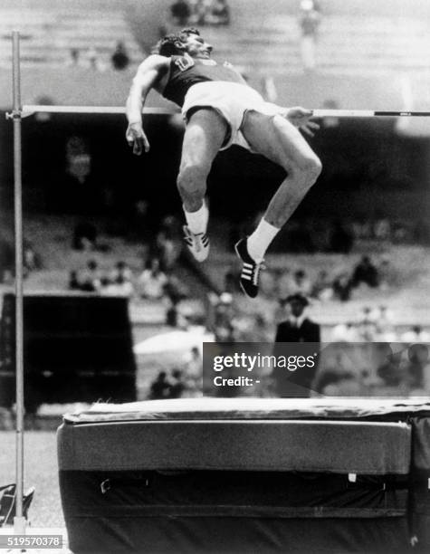 American athlete Dick Fosbury competes in the men's high jump final and wins the gold medal with a brand new style of jumping, a dorsal technique, on...