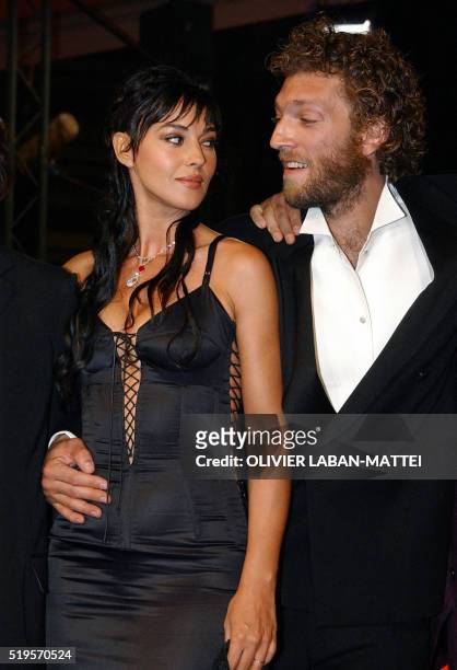Italian actress Monica Bellucci looks at French actor Vincent Cassel as they arrive at the palais des festivals to attend the screening of their...