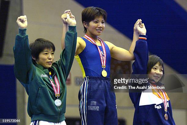 Second place Kumie Matsumiya, first place Mari Nakaga and third place Hiromi Miyake celebrate on the podium at the medal ceremony for the -53kg...