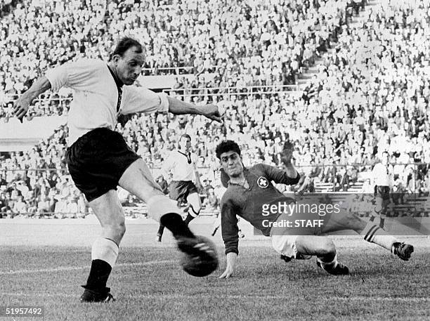 Swiss defender Heinz Schneiter attempts to block the shot of German forward Uwe Seeler 03 June 1962 in Santiago during the World Cup first round...