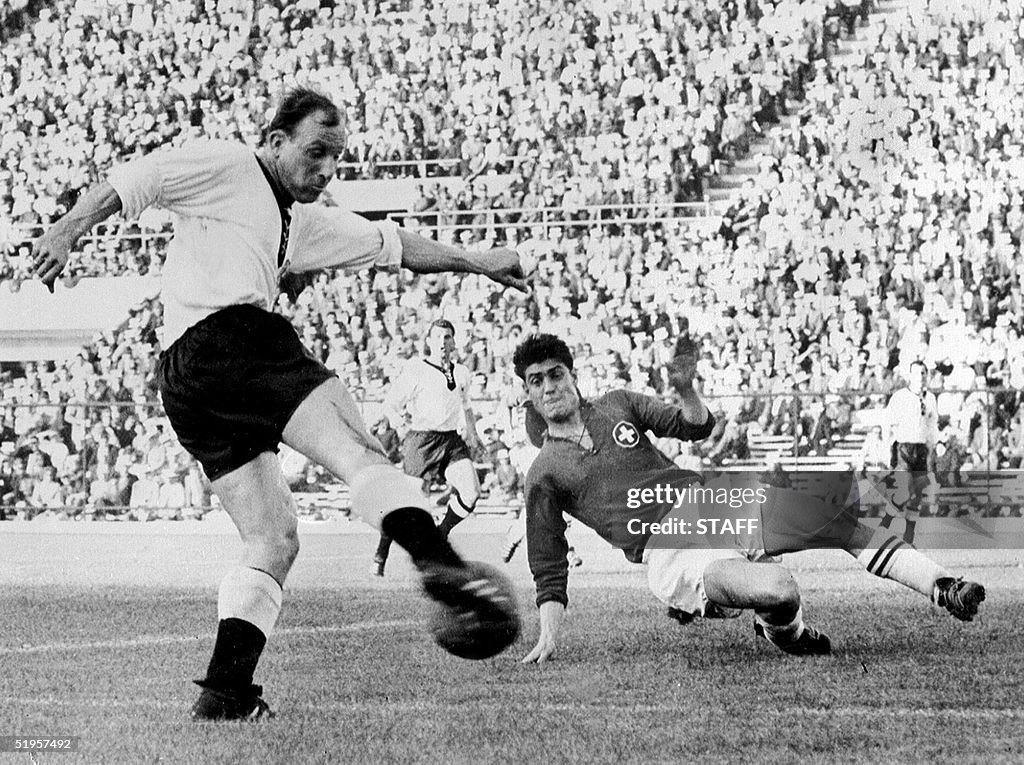 Swiss defender Heinz Schneiter (R) attempts to blo