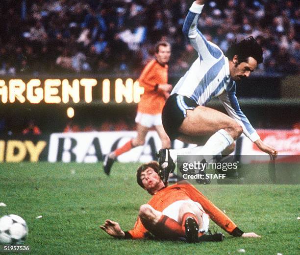 Argentinian forward Leopoldo Luque jumps to avoid the tackle of Dutch defender Erny Brandts, 25 June 1978 in Buenos Aires, during the World Cup...