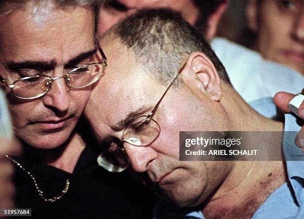 Haim Avraham is comforted by his brother Moshe, after being told by Israeli General Gil Regev, head of the army manpower branch, that his son, Benny...