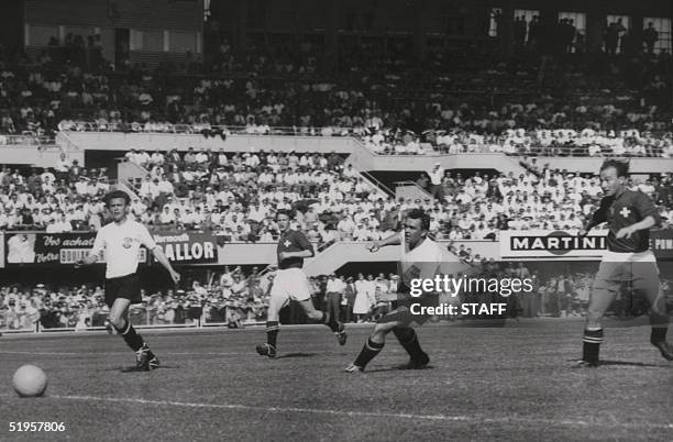 Swiss forward Josef Hugi II scores a goal as teammate forward Charles Antenen , Austrians defenders Leopold Barschandt and Gerhard Hanappi look on...