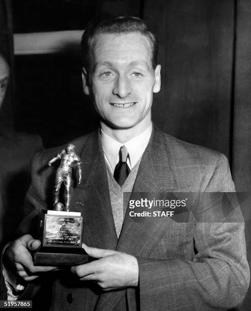 Preston North End's forward Tom Finney smiles as he holds his trophy 29 April 1954 in London after being elected the Footballer of the Year by the...