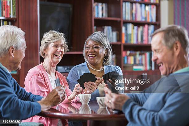 multiracial group of seniors talking, playing card game - retirement card stock pictures, royalty-free photos & images