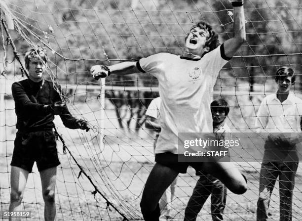 West German midfielder Wolfgang Overath playfully tries his hand as a goalkeeper as regular starter Sepp Maier looks on during practice of the West...