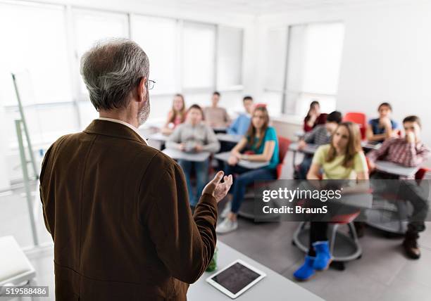 männchen hinteren ansicht eines lehrers geben einen vortrag hält. - male teacher in a classroom stock-fotos und bilder