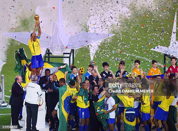 Brazil's team captain and defender Cafu hoists the World Cup trophy, celebrating with his team, following Brazil's 2-0 victory over Germany in match...
