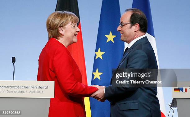 French President Francois Hollande shakes hand with German Chancellor Angela Merkel after a press conference during the 18th Franco-German cabinet...