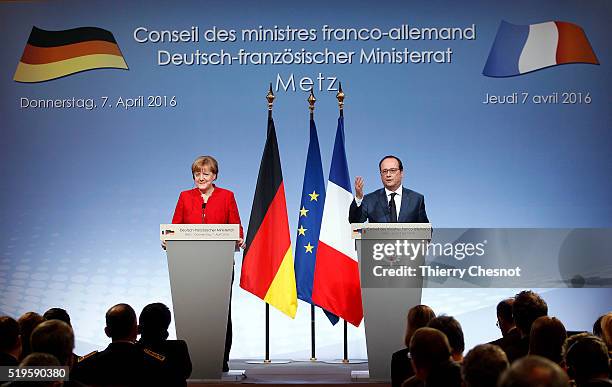 French President Francois Hollande delivers a speech next to German Chancellor Angela Merkel during a press conference after the 18th Franco-German...