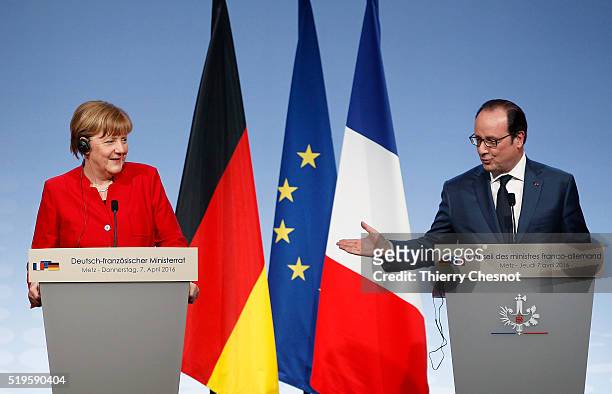 French President Francois Hollande delivers a speech next to German Chancellor Angela Merkel during a press conference after the 18th Franco-German...
