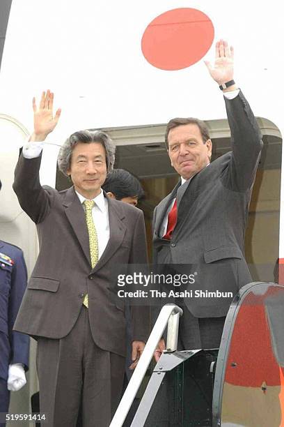 Japanese Prime Minister Junichiro Koizumi and German Chancellor Gerhard Schroder wave on departure for Japan at the Calgary International Airport on...