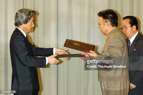 Japanese Prime Minister Junichiro Koizumi and North Korean leader Kim Jong-il exchange the documents after signing the Pyongyang Declaration...