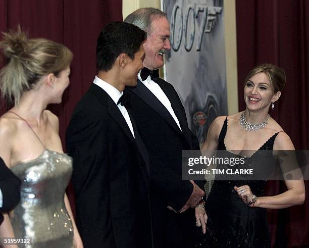 Madonna shares a joke with John Cleese as they wait in line to meet Queen Elizabeth II and The Duke of Edinburgh at the premiere of "Die Another...