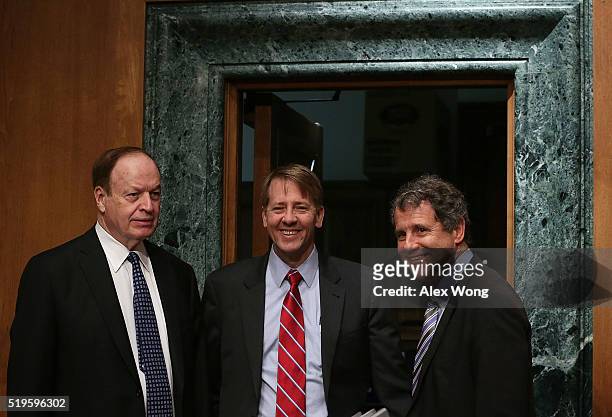 Director of the Consumer Financial Protection Bureau Richard Cordray poses for photographers with committee chairman Sen. Richard Shelby and ranking...