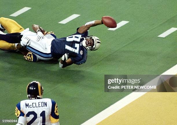 Tennessee Titans wide receiver Kevin Dyson stretches for the end zone but falls short as he is tackled by St. Louis Rams linebacker Mike Jones as...