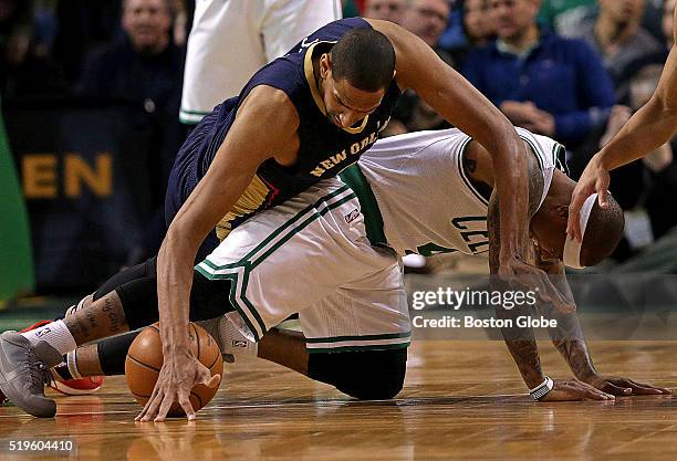 Boston Celtics guard Isaiah Thomas appears to hurt himself as he and New Orleans Pelicans center Alexis Ajinca and Boston Celtics guard Avery Bradley...