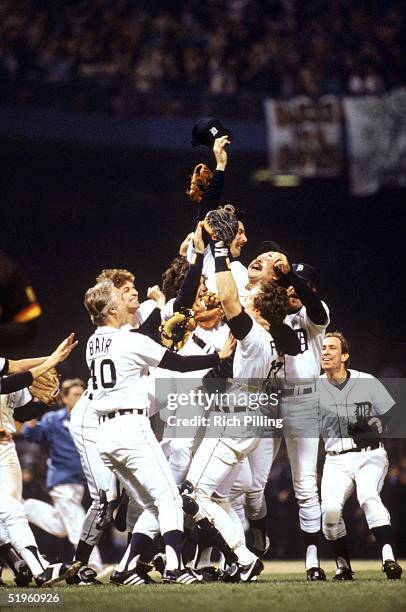 Catcher Lance Parrish of the Detroit Tigers holds up teammate pitcher Wille Hernandez as the Tigers celebrate on the field after winning game 5 of...