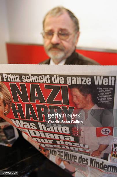 Man reads the day's issue of the German tabloid "Bild", which features the story of British Prince Harry attending a party dressed in a Nazi uniform...