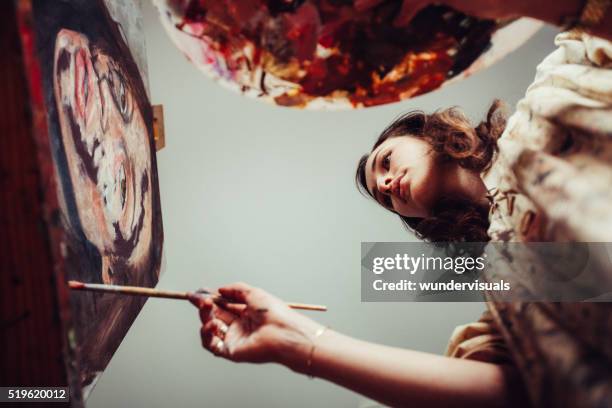 artist painting on a canvas with brush and palette - fine art painting stock pictures, royalty-free photos & images
