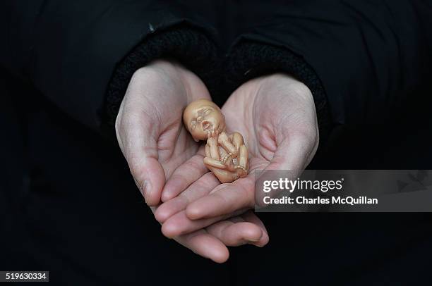 Pro Life campaigner displays a plastic doll representing a 12 week old foetus as she stands outside the Marie Stopes Clinic on April 7, 2016 in...