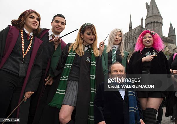 Fans pose with actor Warwick Davis in front of Hogwarts castle at the Grand Opening of the 'Wizarding World of Harry Potter' to the public at...