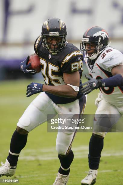 Tight end Antonio Gates of the San Diego Chargers attempts to evade safety Kenoy Kennedy of the Denver Broncos during the game on December 5, 2004 at...