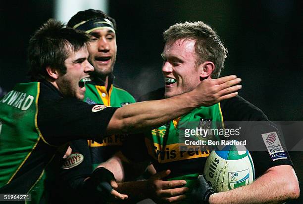 Mark Soden of Northampton is congratulated on scoring a try by Johnny Howard and Andrew Blowers during the Heineken Cup Pool three match between...