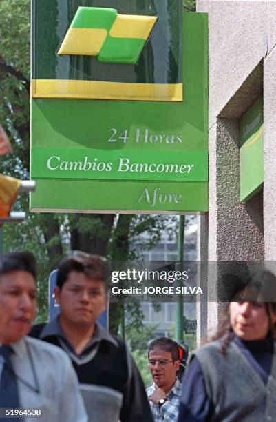 Passers-by walk in front of a ATM at the Bancomer Bank in Mexico City, 10 March, 2000. Transeuntes caminan frente a un cajero automatico del Banco...