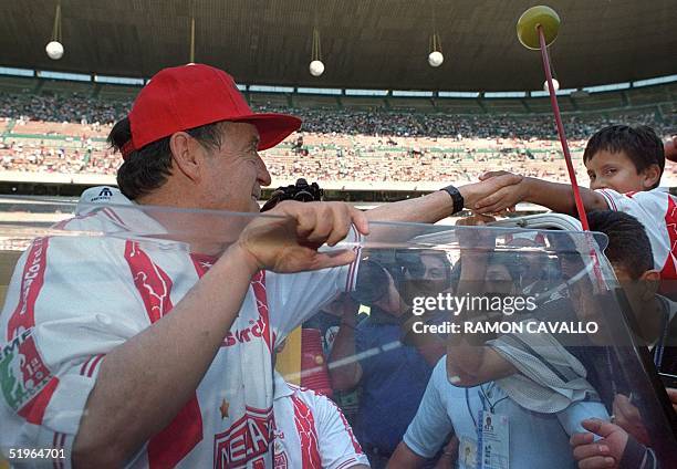 Famous comedian, Chespirito greets a boy during the tribute in Aztec stadium in Mexico 01 April 2000. El popular comediante Chespirito saluda a un...