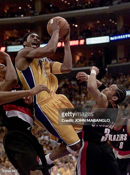 Los Angeles Lakers' Kobe Bryant goes up to score before Portland Trail Blazers' Damon Stoudamire and Blazers Scottie Pippen during the first quarter...