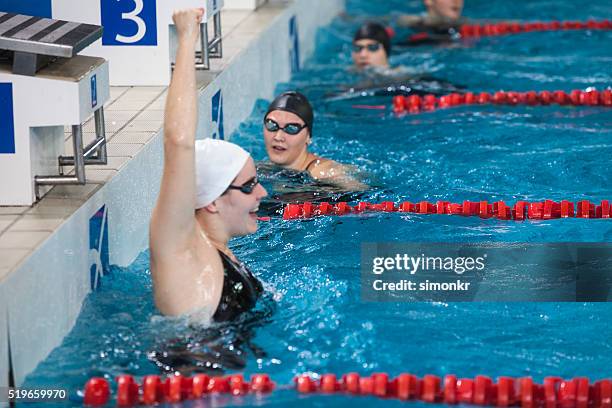 weibliche schwimmer im swimmingpool - schwimmwettkampf stock-fotos und bilder