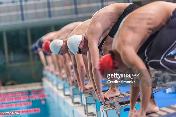 male swimmer on starting block - swim meet stock pictures, royalty-free photos & images
