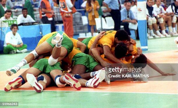 The Brazilian volleyball team pile on top of each other 09 August 1992 after defeating the Dutch team to win the gold medal at the 1992 Summer...