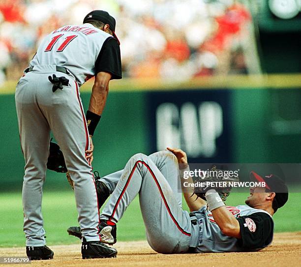 Cincinnati Reds shortstop Barry Larkin looks at teammate Aaron Boone after Boone injured his knee while trying avoid a collision with Larkin while...