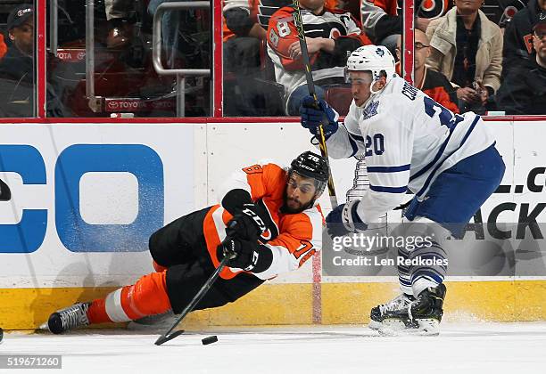 Pierre-Edouard Bellemare of the Philadelphia Flyers falls to the ice while playing the loose puck against Frank Corrado of the Toronto Maple Leafs on...