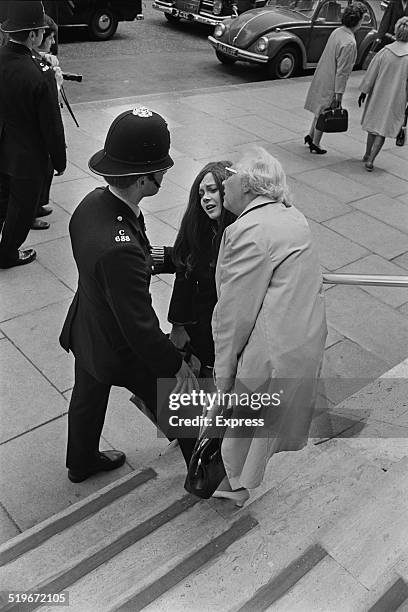 Policeman comforts a grieving woman outside the American Embassy after the assassination of Senator Robert Kennedy, 6th June 1968.